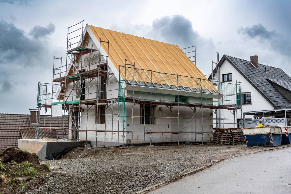 Casa de dos pisos en construcción con andamios alrededor